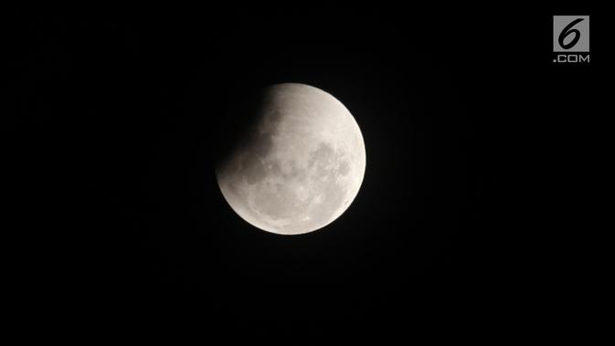 A view of the penumbra as it begins to cover the surface of the moon during the process of the lunar eclipse seen over the Jakarta sky, Wednesday (31/1).  This Total Lunar Eclipse is accompanied by a Supermoon and a Blue Moon.  (Liputan6.com/Arya Manggala)
